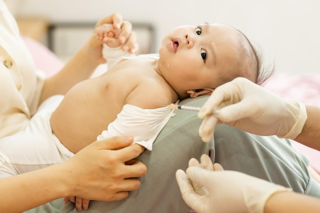 Retrato de un bebé siendo vacunado por un médico