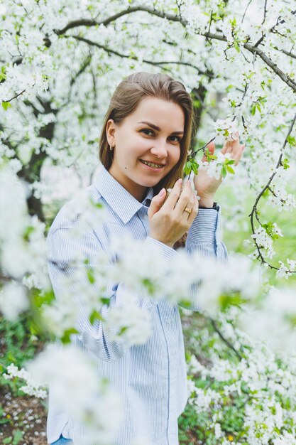 Retrato de bella dama romántica en flores de manzanos