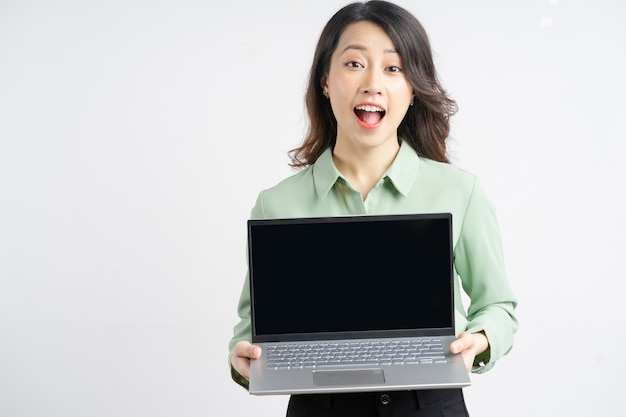 Retrato de una bella empresaria asiática sosteniendo su computadora portátil con una pantalla vacía