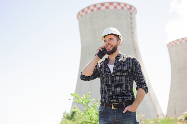 Retrato de una bella ingeniera en el trabajo con el teléfono