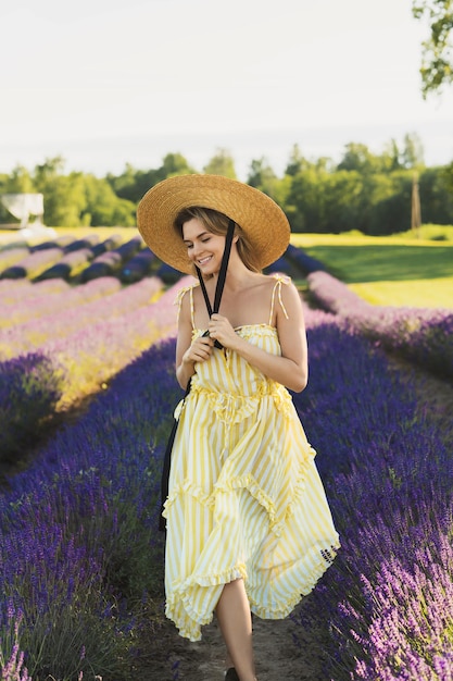 Retrato de una bella joven en un campo lleno de flores de lavanda