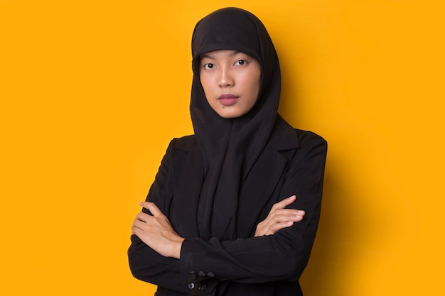 Retrato de una bella joven musulmana seria vistiendo un hijab negro