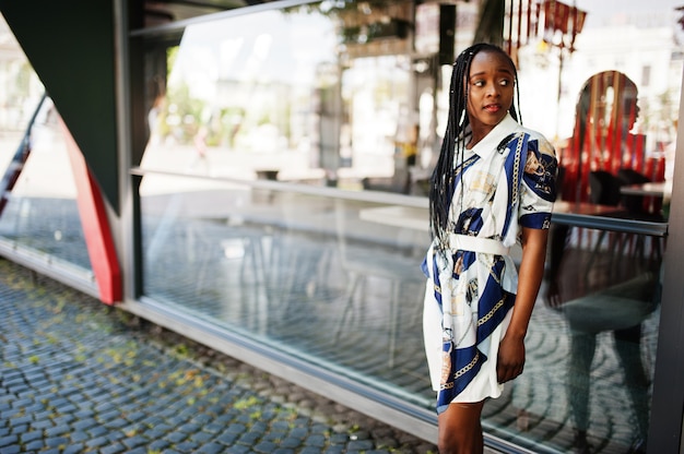 Retrato de una bella mujer africana natural joven con pelo afro en vestido.