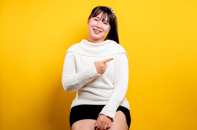 Retrato de una bella mujer asiática con una cara sonriente. Mujer asiática con ropa casual. Estilo de vida tailandés. linda chica sonrisa brillante sobre un fondo amarillo