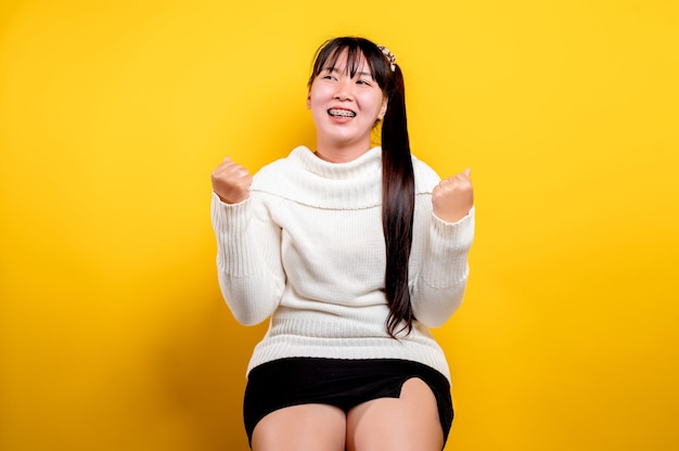 Retrato de una bella mujer asiática con una cara sonriente. Mujer asiática con ropa casual. Estilo de vida tailandés. linda chica sonrisa brillante sobre un fondo amarillo