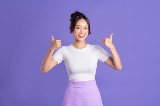 Retrato de una bella mujer asiática posando sobre un fondo morado