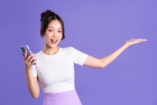 Retrato de una bella mujer asiática posando sobre un fondo morado