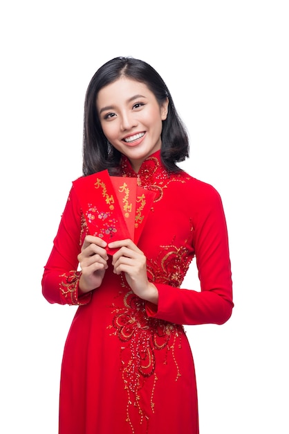 Retrato de una bella mujer asiática en traje de fiesta tradicional Ao Dai con bolsillo rojo - dinero de la suerte. Tet vacaciones. Año Nuevo Lunar.