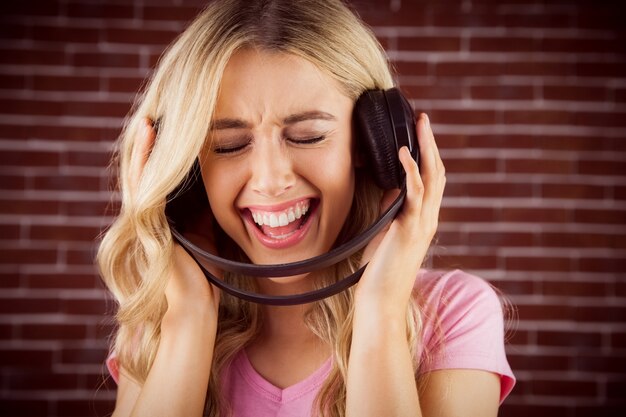 Retrato de una bella mujer cantando con auriculares