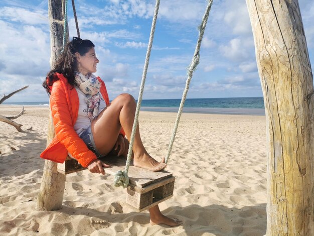 Retrato de una bella mujer descansando en la playa con una sonrisa en el otoño