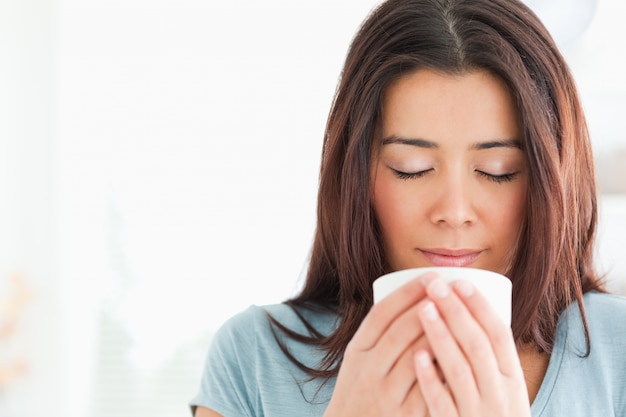 Retrato de una bella mujer disfrutando de una taza de café