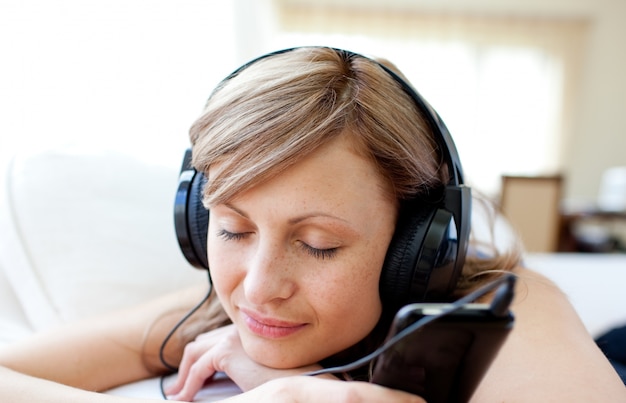 Retrato de una bella mujer escuchando la música con auriculares