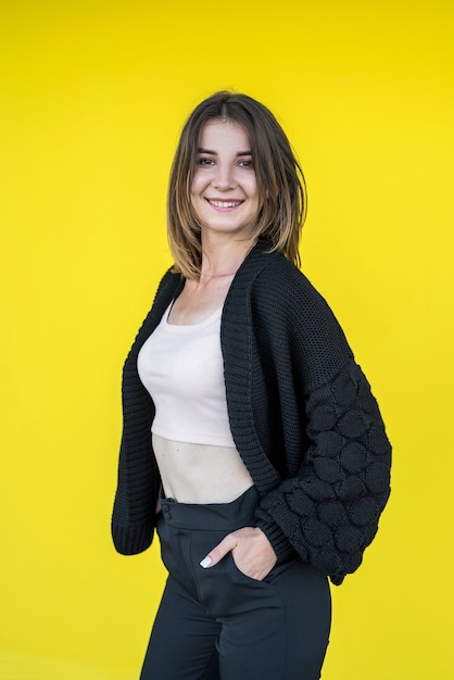 Retrato de una bella mujer joven cerca de la pared amarilla. estilo de vida