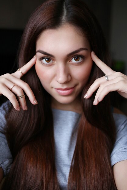 Retrato de una bella mujer joven, dedos en la sien