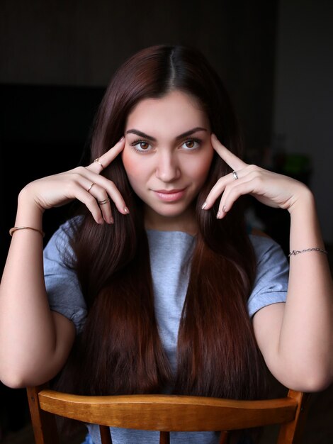 Retrato de una bella mujer joven, dedos en la sien