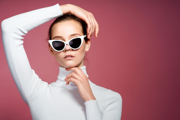 Retrato de una bella mujer joven con gafas de sol