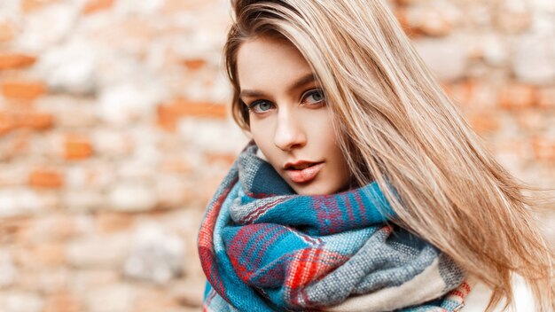 Retrato de una bella mujer joven con ojos azules en la calle