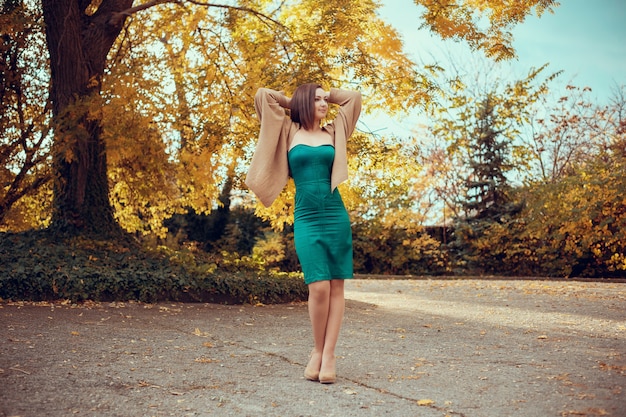 Retrato de una bella mujer joven en un parque de otoño. fotos en colores cálidos