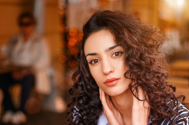 Retrato de una bella mujer joven con el pelo rizado de cerca