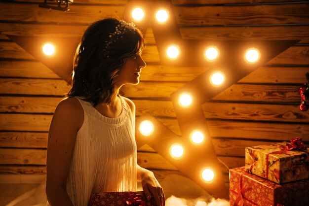 Retrato de una bella mujer joven que tiene un regalo para año nuevo y Navidad.