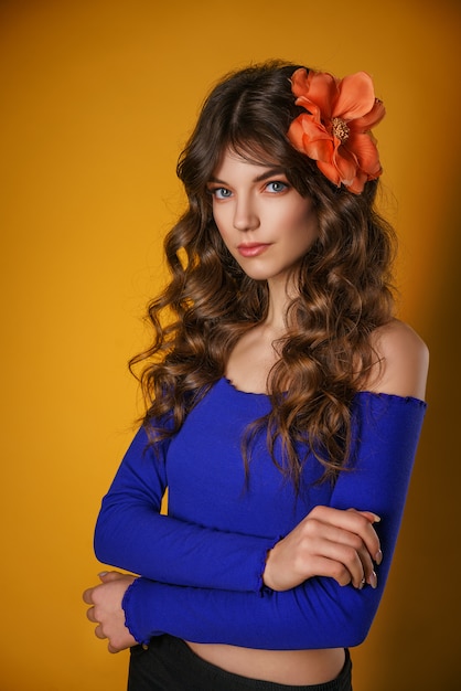 Retrato de una bella mujer joven sobre un fondo amarillo,