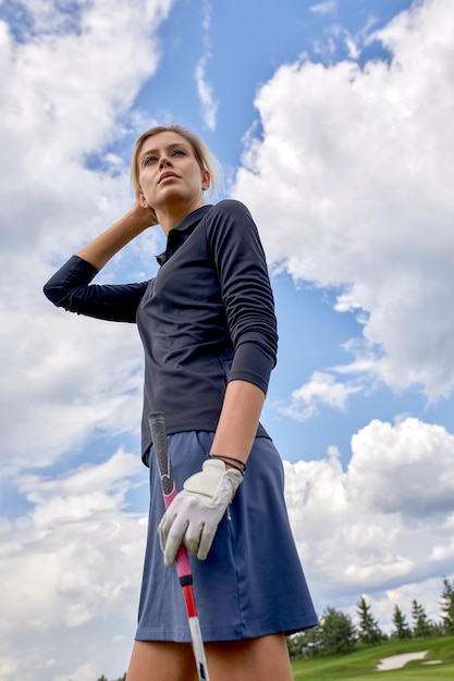 Retrato de una bella mujer jugando al golf en un campo verde al aire libre antecedentes El concepto de golf la búsqueda de la excelencia excelencia personal deporte real