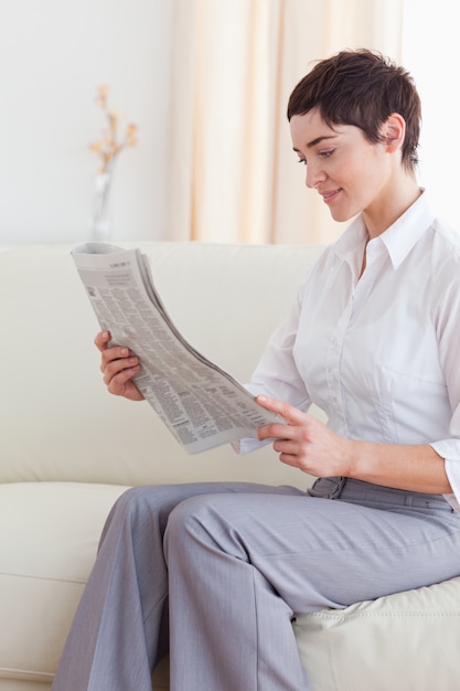 Foto retrato de una bella mujer morena leyendo las noticias