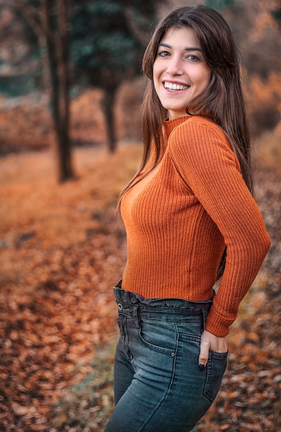 Retrato de una bella mujer sonriente en bosque otoñal