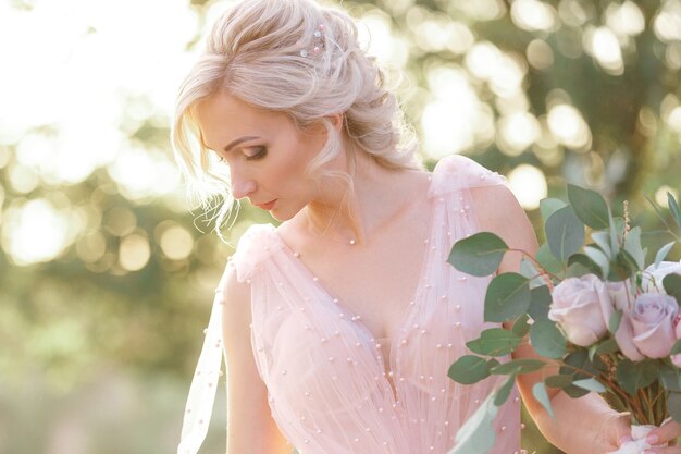 Retrato de la bella novia con ramo de flores en la naturaleza. fotografía de bellas artes.