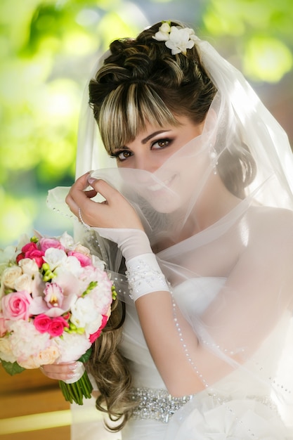 Retrato de una bella novia con un ramo de flores