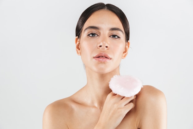 Retrato de la belleza de una atractiva mujer sana que se encuentran aisladas sobre una pared blanca, con soplo de polvo