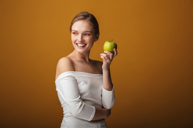 Retrato de belleza de una bella mujer joven sensual aislada, sosteniendo manzana verde