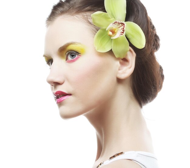 Retrato de belleza. Hermosa chica elegante con flor de orquídea en el pelo.