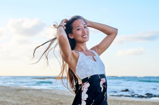 Retrato de belleza de una hermosa joven con el pelo largo en la playa del mar