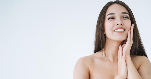 Foto retrato de belleza de una joven asiática con cabello largo y oscuro en un fondo blanco