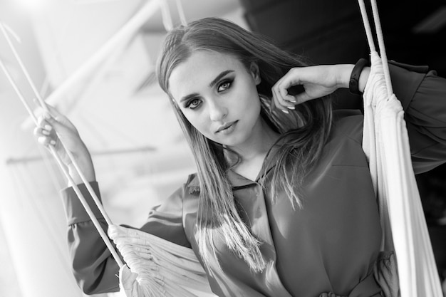 Retrato de la belleza de una joven y bella chica morena con el pelo largo y recto negro volando. Magnífico cabello. Foto en blanco y negro.