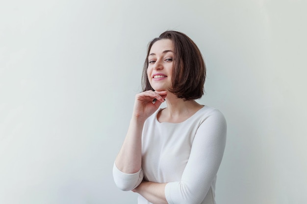 Retrato de belleza joven mujer morena positiva feliz sobre fondo blanco aislado