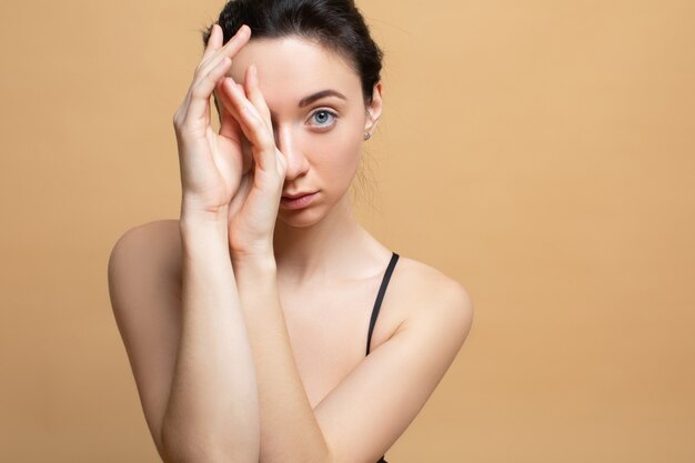 Retrato de la belleza de una joven sobre un fondo naranja