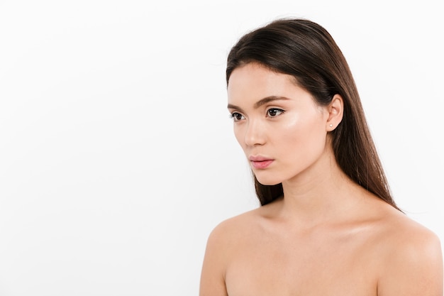 Foto retrato de belleza en media vuelta de mujer bonita asiática con cabello largo castaño, aislado en blanco