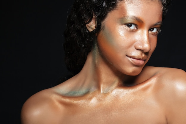 Retrato de belleza de mujer joven americana atractiva con maquillaje elegante sobre negro