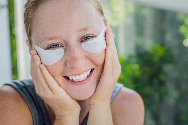 Retrato de belleza Mujer pelirroja con parches en los ojos que muestran un efecto de piel perfecta. Chica de spa.