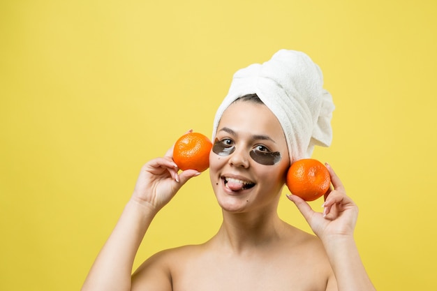 Retrato de belleza de mujer en toalla blanca en la cabeza con mascarilla nutritiva dorada en la cara Cuidado de la piel