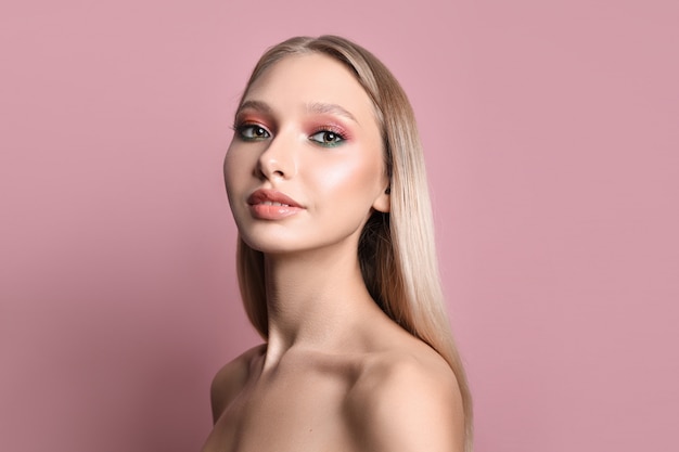 Retrato de belleza de una niña con maquillaje perfecto en su rostro, sombra de ojos coloreada, cabello largo y hermoso