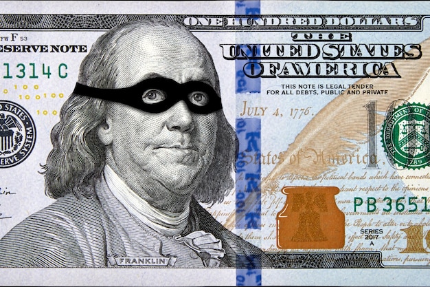 Retrato de Benjamin Franklin con una máscara negra de ladrón en un billete de cien dólares