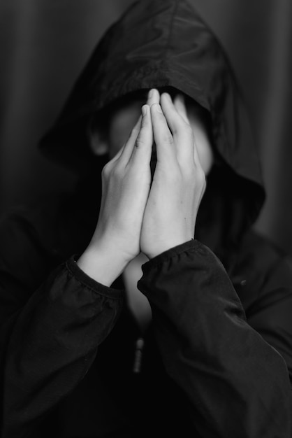 Retrato en blanco y negro de un adolescente sobre fondo oscuro Toma de primer plano de un joven adolescente Fotografía en blanco y negro Enfoque selectivo