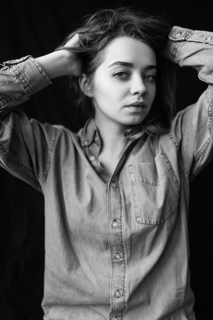 Retrato en blanco y negro de una bella joven modelo de pelo oscuro sobre fondo negro