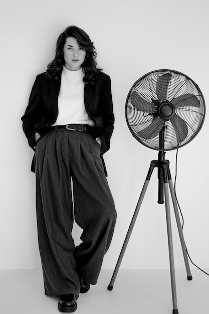 Retrato en blanco y negro de una joven mujer elegante con pantalones anchos y chaqueta