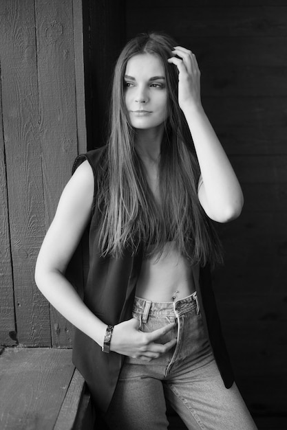 Retrato en blanco y negro de una mujer en estado triste junto a la ventana Retrato de desesperación en pose de moda en chaleco