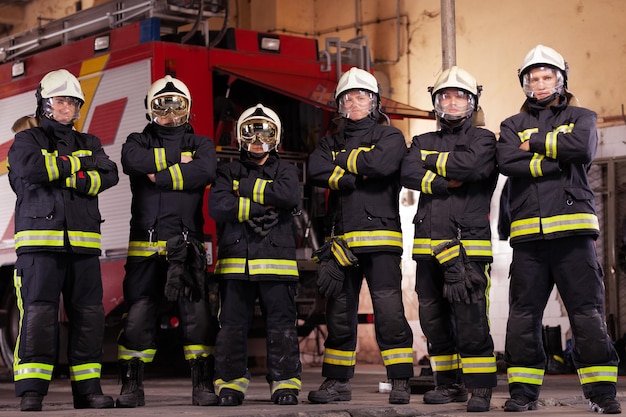 Retrato de bomberos de pie en la estación