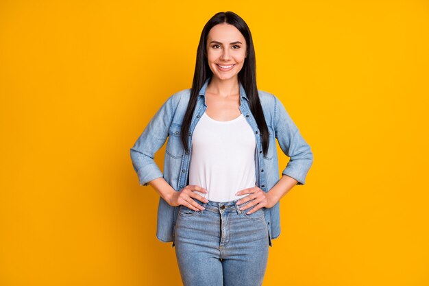 Retrato de bonita chica encantadora con las manos en las caderas